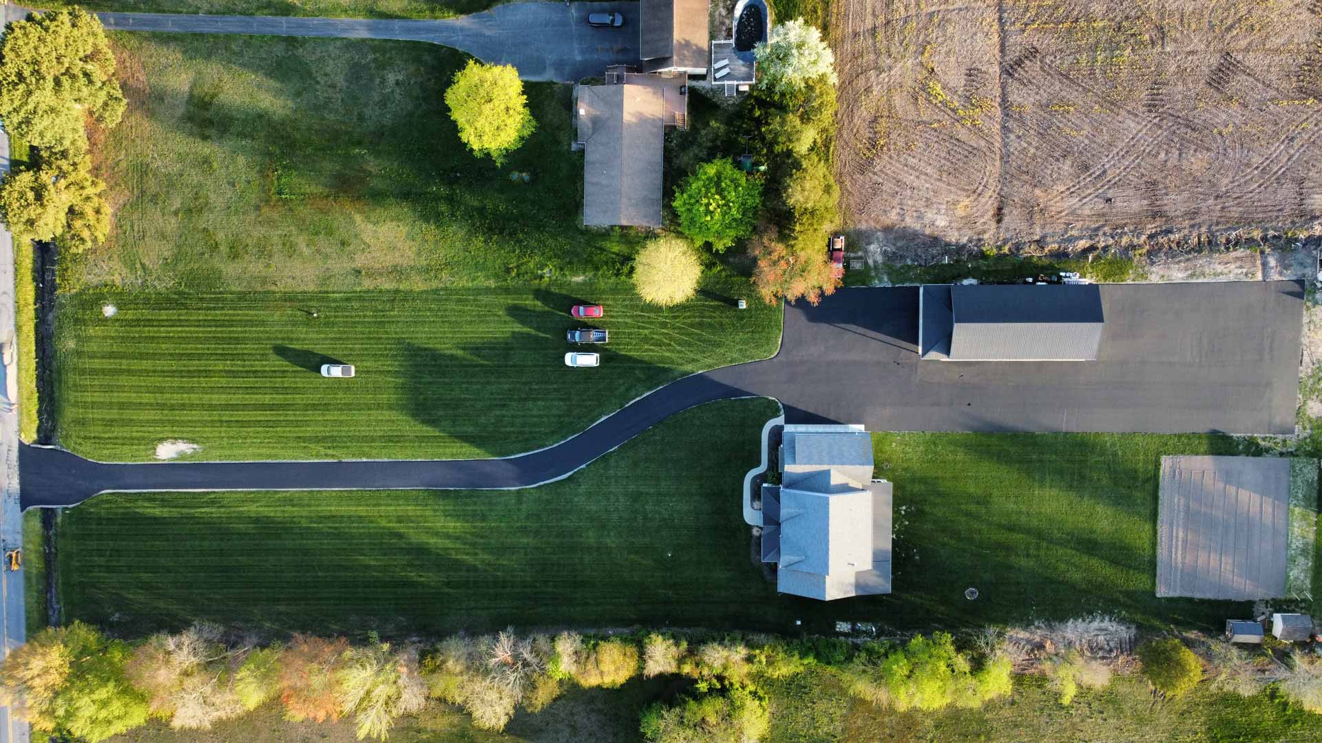 Overhead drone shot of a long, newly paved driveway